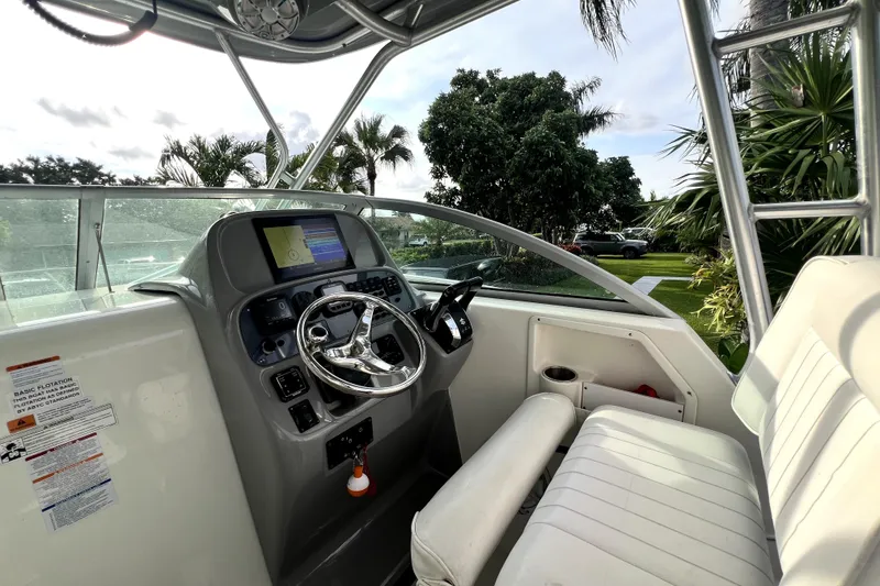 Slide: The Image of 2014 Robalo R265 Walkaround boat cockpit with steering wheel and navigation display. - 129