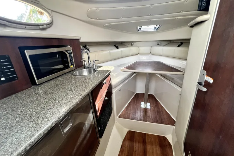 Slide: The Image of 2014 Robalo R265 Walkaround cabin interior with kitchenette and seating area. - 72