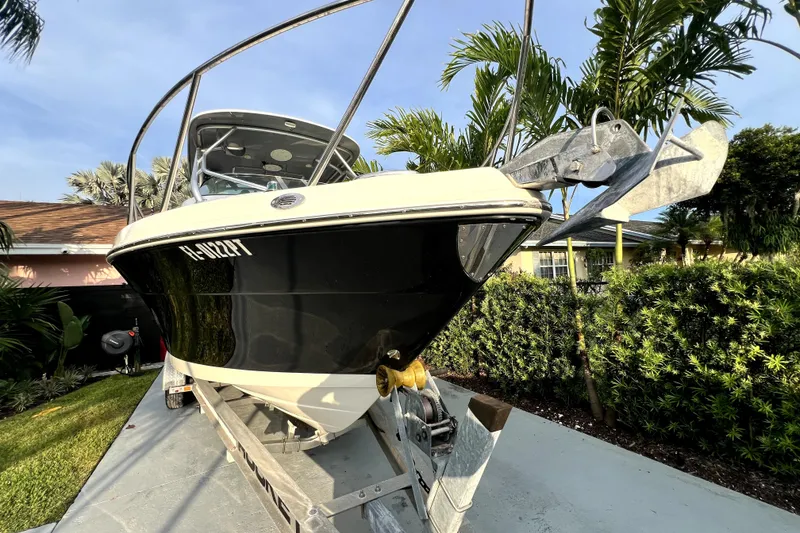 Slide: The Image of Un barco Robalo R265 Walkaround en un remolque, rodeado de palmeras. - 28