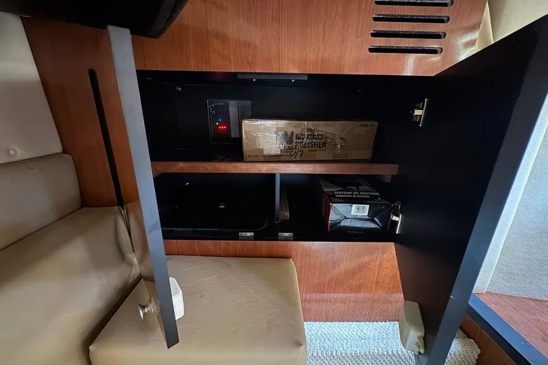 Slide: The Image of Open cabinet inside 2006 Sea Ray 340 Sundancer, showing storage shelves and electronic equipment. - 74