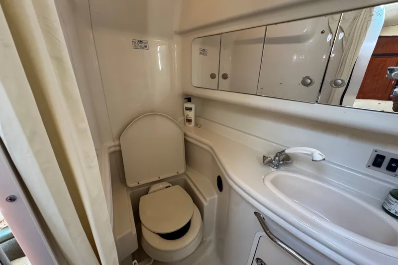 Slide: The Image of 2006 Sea Ray 340 Sundancer bathroom with toilet, sink, and mirrored cabinet. - 79