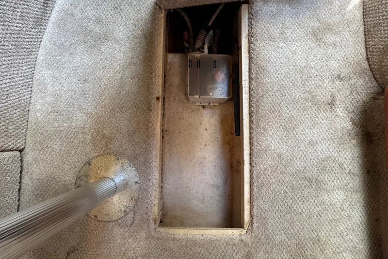 Slide: The Image of Carpeted interior of a 2006 Sea Ray 340 Sundancer boat, showing an open compartment. - 99