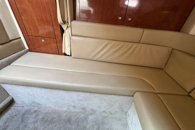 Slide: The Image of Interior seating of 2006 Sea Ray 340 Sundancer with beige upholstery and wooden cabinetry. - 71