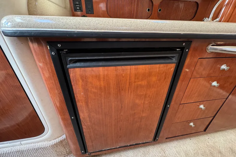 Slide: The Image of 2006 Sea Ray 340 Sundancer interior with wood cabinetry and compact refrigerator. - 93