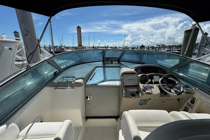 Slide: The Image of 2006 Sea Ray 340 Sundancer cockpit with steering wheel, Garmin navigation, and marina view. - 30