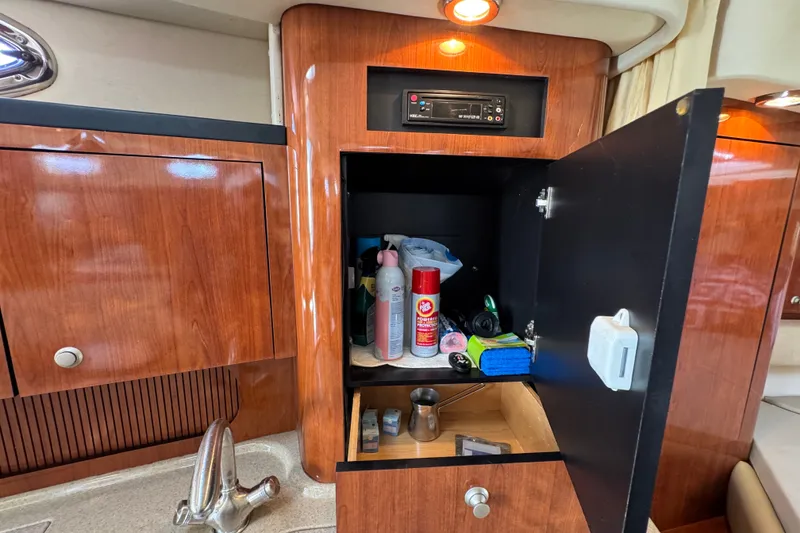 Slide: The Image of Interior cabinet of 2006 Sea Ray 340 Sundancer with open door revealing stored items. - 92