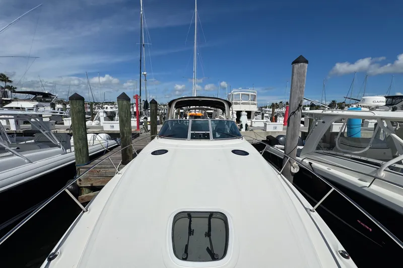 Slide: The Image of 2006 Sea Ray 340 Sundancer docked at a marina under a clear blue sky. - 56