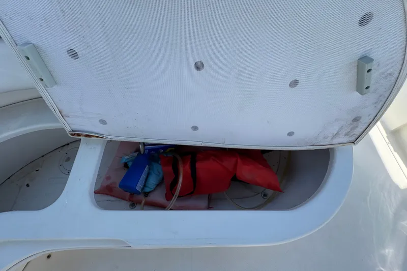 Slide: The Image of Open storage compartment on 2006 Sea Ray 340 Sundancer boat with life jackets inside. - 24