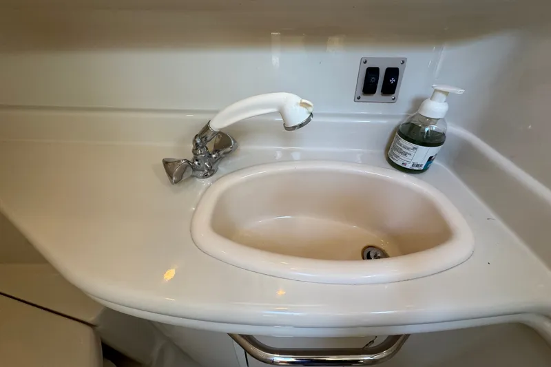 Slide: The Image of Bathroom sink area in a 2006 Sea Ray 340 Sundancer yacht, featuring faucet and soap dispenser. - 81