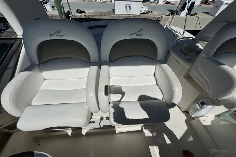 Slide: The Image of 2006 Sea Ray 340 Sundancer cockpit with dual white seats and shadow. - 33