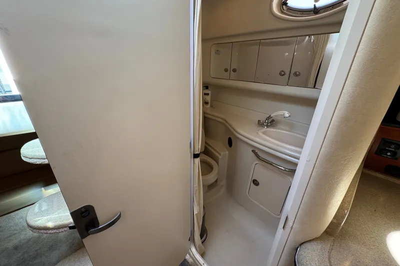 Slide: The Image of 2006 Sea Ray 340 Sundancer bathroom interior with sink, toilet, and storage cabinets. - 78