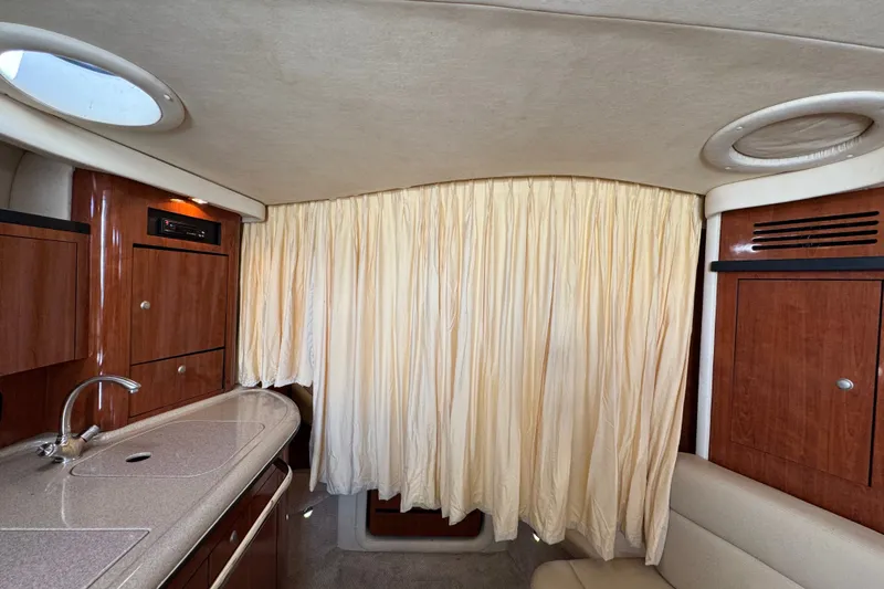 Slide: The Image of Interior of 2006 Sea Ray 340 Sundancer with wood cabinetry and beige curtains. - 101