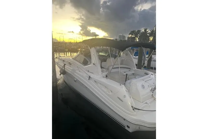 The Image of 2006 Sea Ray 340 Sundancer yacht docked at sunset, featuring sleek white design. - 7