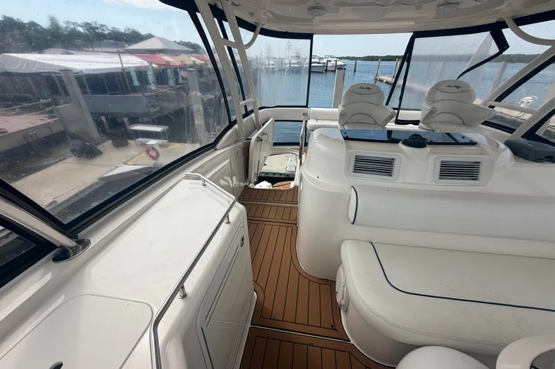 Slide: The Image of 2006 Sea Ray 550 Sedan Bridge interior with seating and helm, docked at marina. - 59