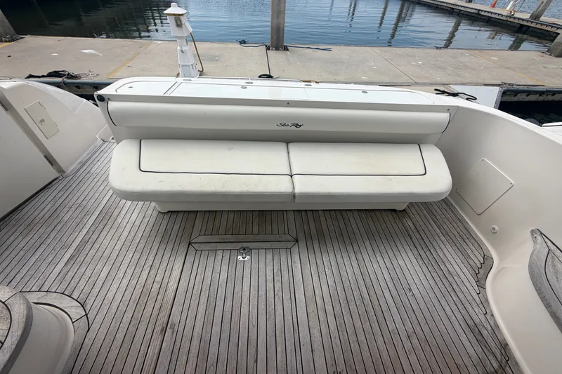 Slide: The Image of 2006 Sea Ray 550 Sedan Bridge yacht deck with cushioned seating and wooden flooring. - 47