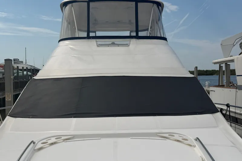 Slide: The Image of 2006 Sea Ray 550 Sedan Bridge yacht docked, featuring sleek design and covered windshield. - 35