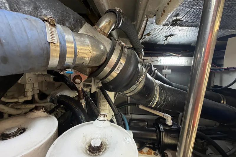 Slide: The Image of Engine room of 2006 Sea Ray 550 Sedan Bridge with visible pipes and fittings. - 146