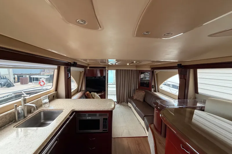 Slide: The Image of Luxurious interior of 2006 Sea Ray 550 Sedan Bridge yacht with modern kitchen and seating area. - 113