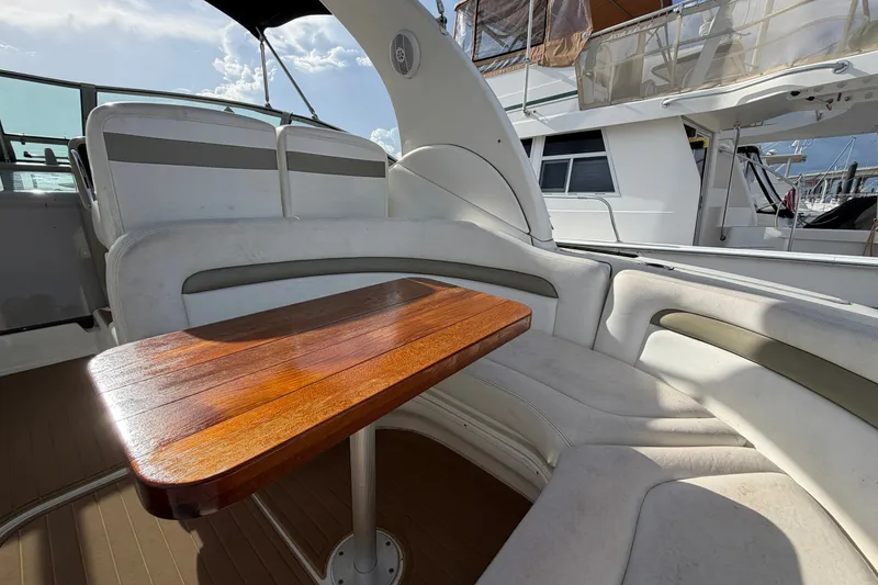 Slide: The Image of Interior of 2006 Sea Ray Sundancer 320 with wooden table and cushioned seating. - 35