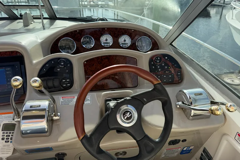 Slide: The Image of 2006 Sea Ray Sundancer 320 helm with gauges, steering wheel, and throttle controls. - 45
