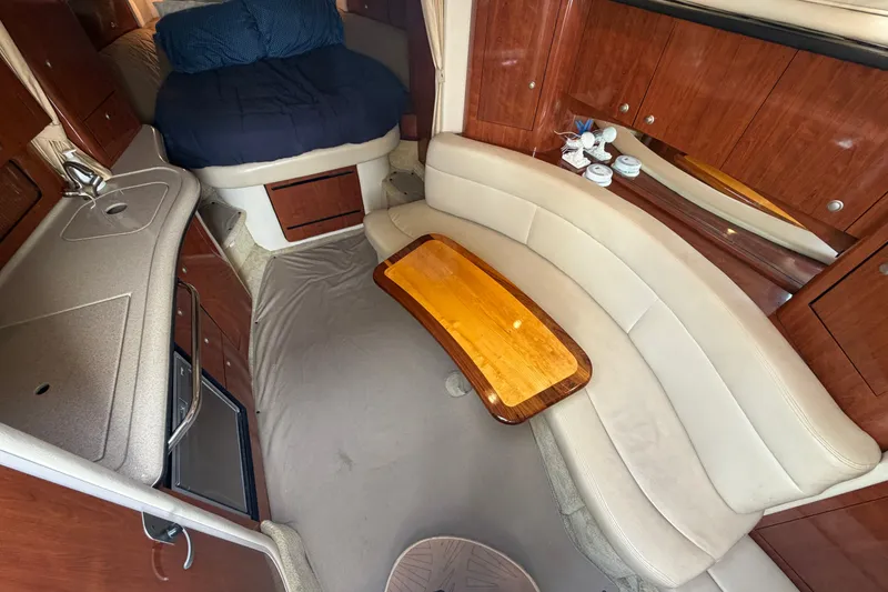 Slide: The Image of 2006 Sea Ray Sundancer 320 cabin interior with kitchenette, seating, and bed. - 77