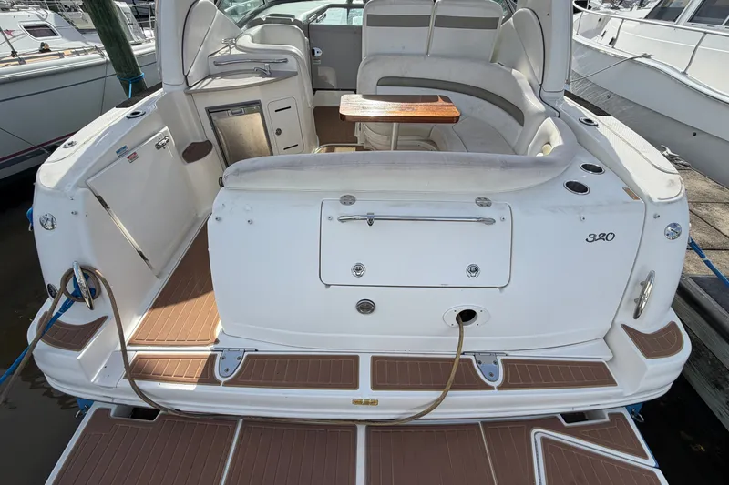 Slide: The Image of 2006 Sea Ray Sundancer 320 boat interior with seating and wooden table, docked at marina. - 31