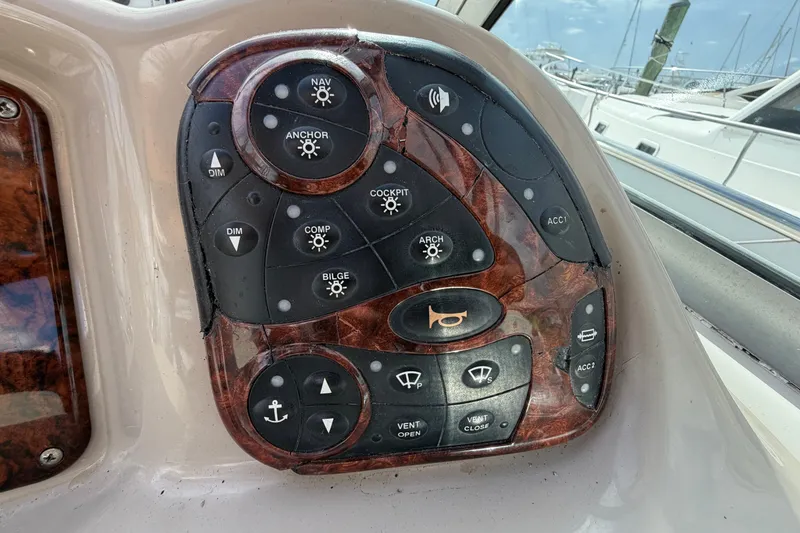 Slide: The Image of Control panel of a 2006 Sea Ray Sundancer 320 boat with various function buttons. - 59