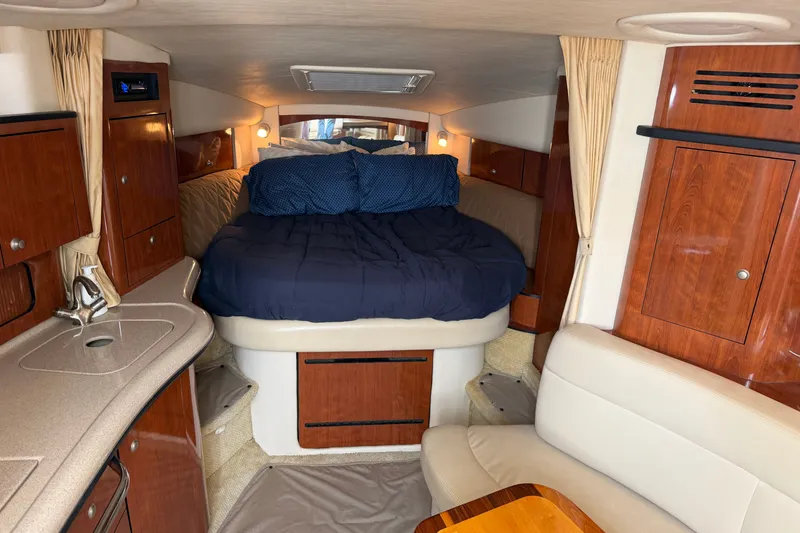 Slide: The Image of 2006 Sea Ray Sundancer 320 cabin interior with bed, kitchenette, and seating area. - 67