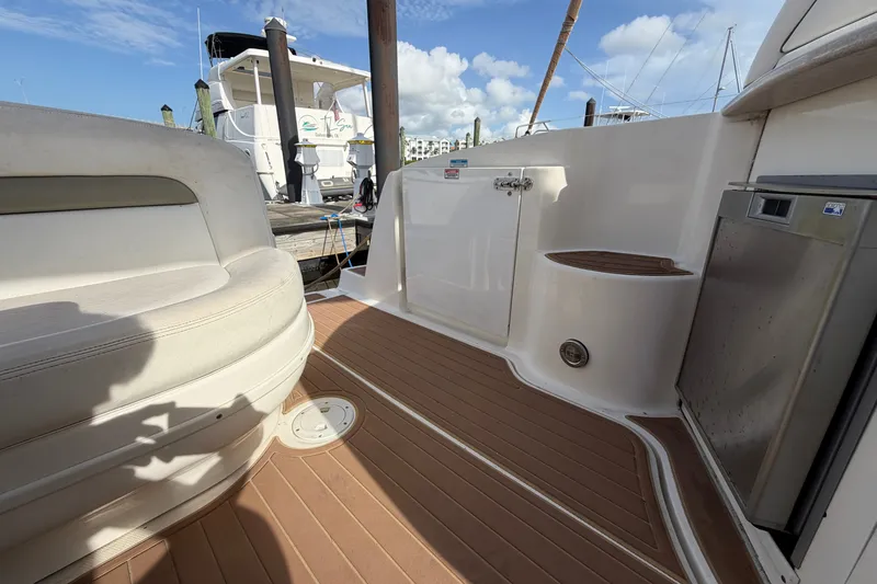 Slide: The Image of 2006 Sea Ray Sundancer 320 boat deck with seating and storage, docked at marina. - 53