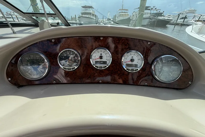 Slide: The Image of Dashboard of a 2006 Sea Ray Sundancer 320 boat with gauges and wood paneling. - 57