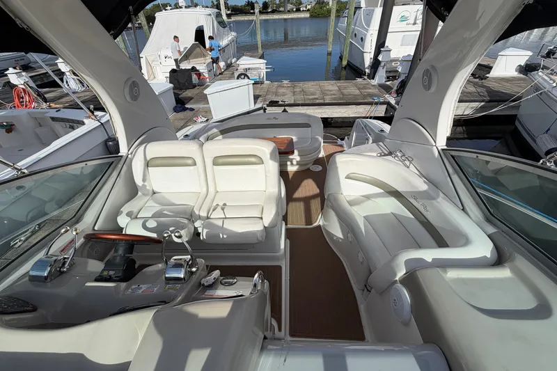 Slide: The Image of 2006 Sea Ray Sundancer 320 yacht interior with white seating and control panel at marina. - 48