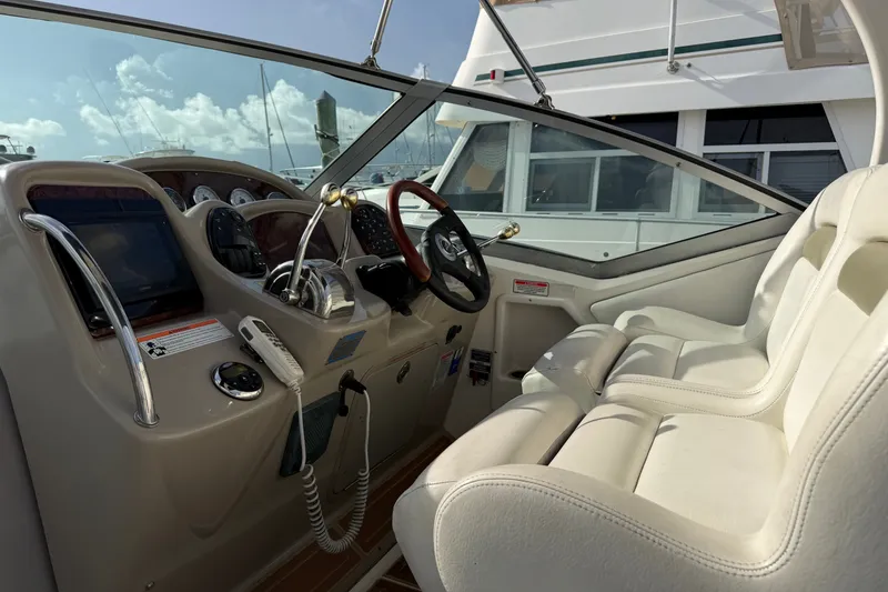 Slide: The Image of 2006 Sea Ray Sundancer 320 cockpit with dual white seats and modern controls. - 42