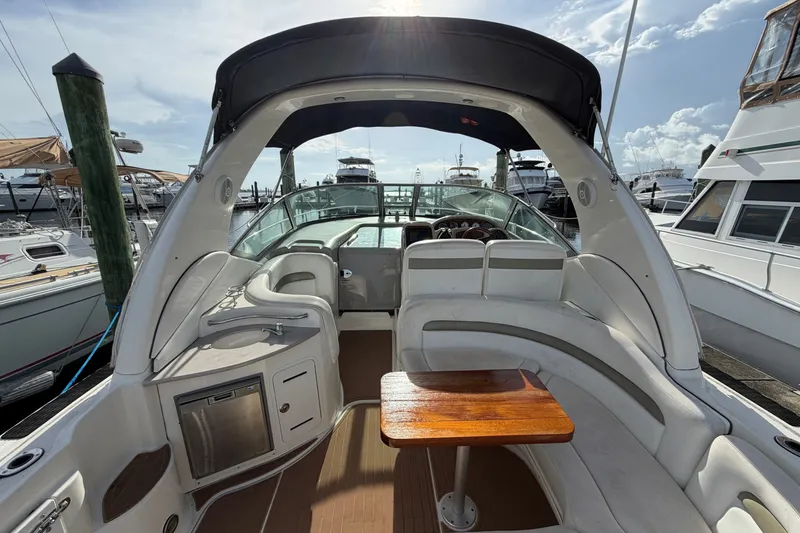 Slide: The Image of 2006 Sea Ray Sundancer 320 yacht interior with seating and table, docked at marina. - 34
