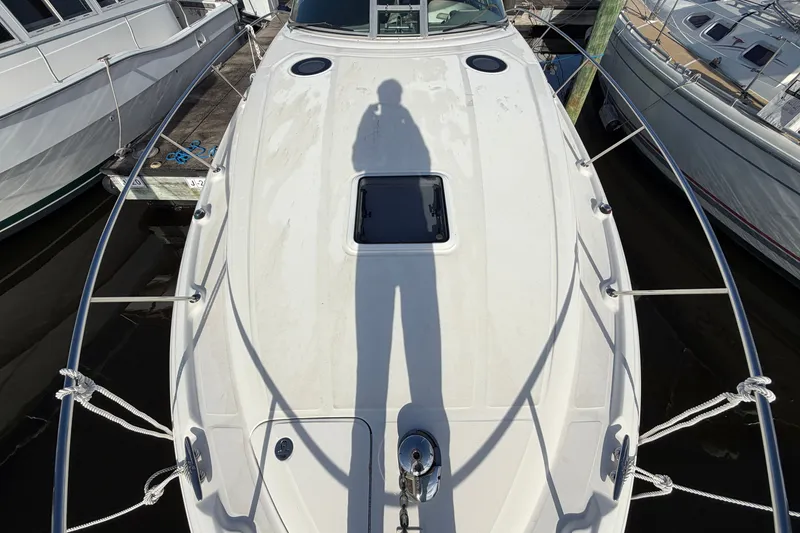 Slide: The Image of 2006 Sea Ray Sundancer 320 yacht deck with shadow, docked among other boats. - 18