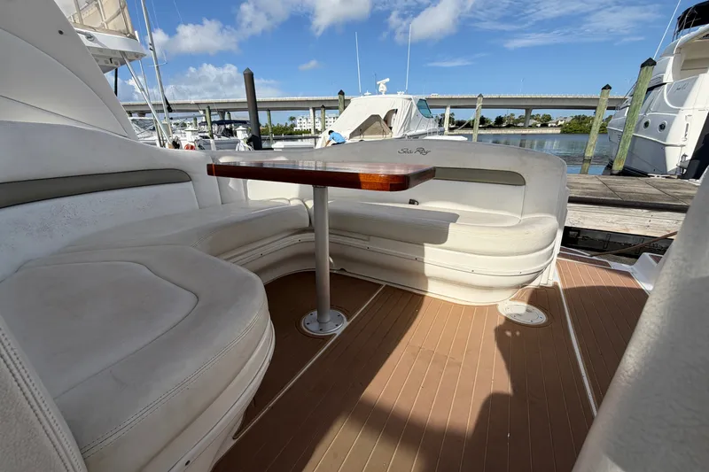 Slide: The Image of 2006 Sea Ray Sundancer 320 yacht interior with seating and table, docked by the water. - 51