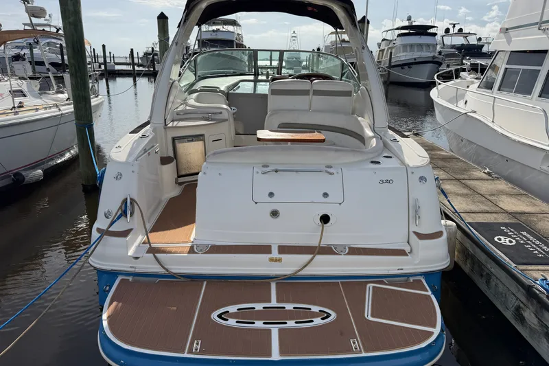 Slide: The Image of 2006 Sea Ray Sundancer 320 docked at marina, showcasing spacious deck and seating area. - 30