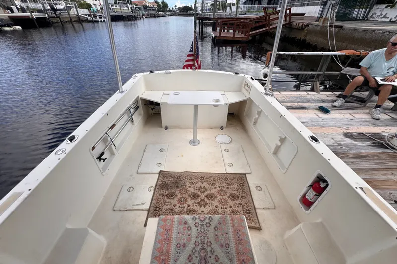 Slide: The Image of 2005 Atlas Boat Works Acadia 25 docked, featuring spacious deck and American flag. - 44