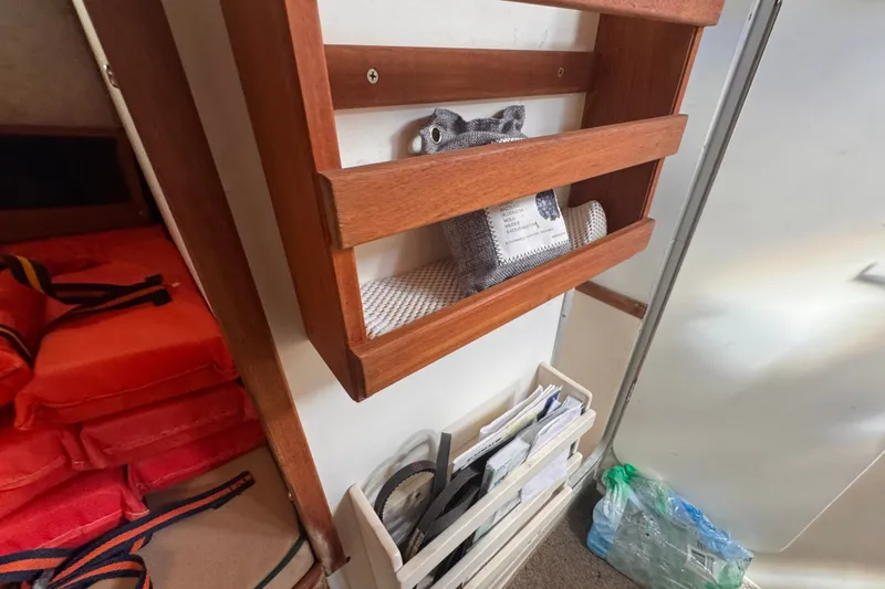 Slide: The Image of Interior of 2005 Atlas Boat Works Acadia 25 with wooden shelves and life jackets. - 37