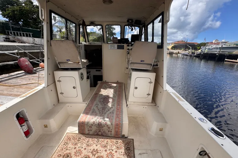 Slide: The Image of Interior of 2005 Atlas Boat Works Acadia 25, featuring seating and a patterned rug. - 9
