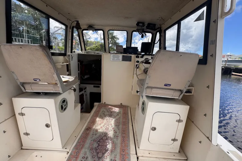 Slide: The Image of Interior of 2005 Atlas Boat Works Acadia 25, featuring helm and seating area. - 10