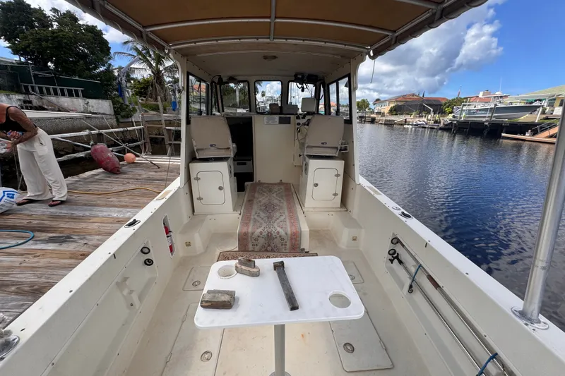 Slide: The Image of 2005 Atlas Boat Works Acadia 25 docked, showcasing spacious interior and helm area. - 7