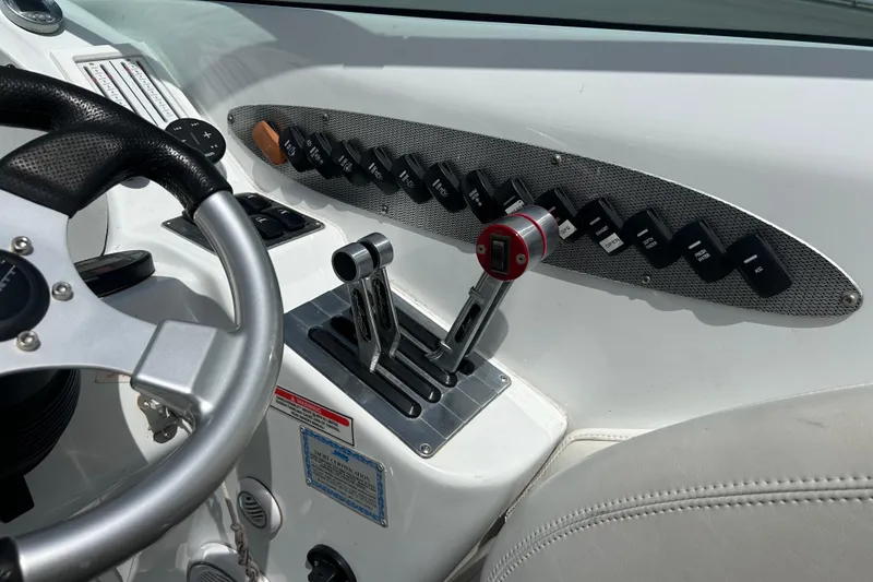 Slide: The Image of 2005 Baha Cruisers 302 boat dashboard with steering wheel and control switches. - 36