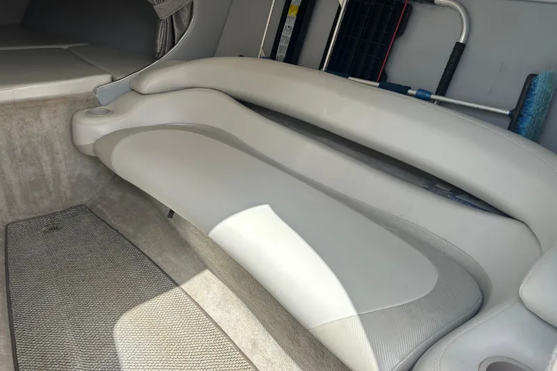 Slide: The Image of Interior seating of a 2005 Baha Cruisers 302 boat, featuring beige upholstery. - 42
