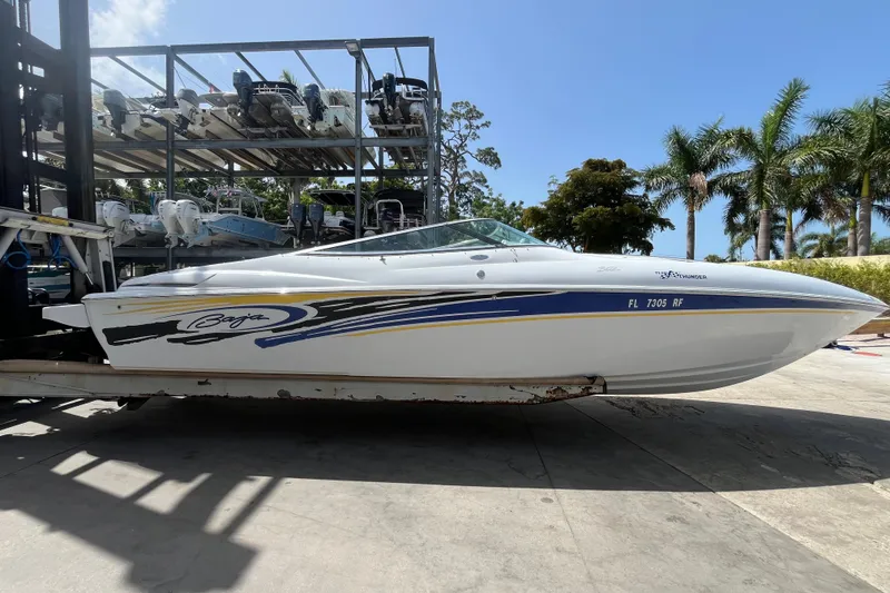 Slide: The Image of 2005 Baha Cruisers 302 boat on trailer, parked outdoors with palm trees in background. - 11