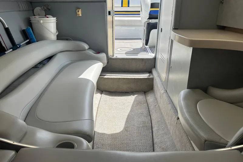 Slide: The Image of Interior of a 2005 Baha Cruisers 302 boat, featuring gray seating and carpeted flooring. - 56