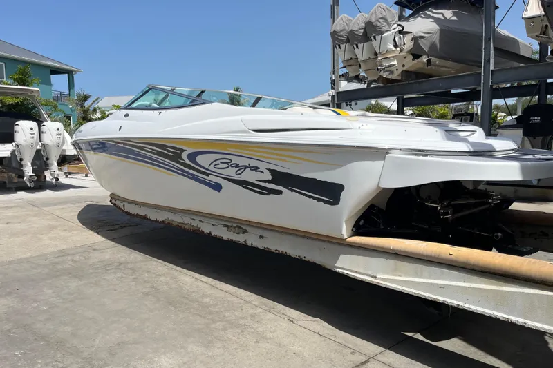 Slide: The Image of 2005 Baha Cruisers 302 boat on trailer, vibrant graphics, sunny day. - 2