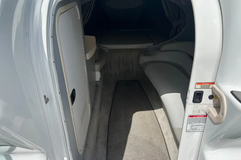 Slide: The Image of Interior cabin of a 2005 Baha Cruisers 302 boat, featuring seating and a door. - 40