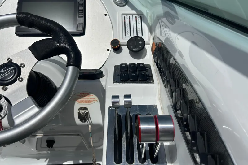Slide: The Image of Control panel of a 2005 Baha Cruisers 302 boat with steering wheel and throttle levers. - 37