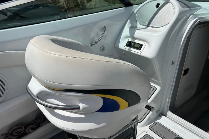 Slide: The Image of Interior of a 2005 Baha Cruisers 302 boat featuring a white captain's chair and control panel. - 23