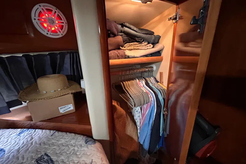 Slide: The Image of Closet inside 2005 Carver 36 Motor Yacht with clothes and a straw hat. - 100
